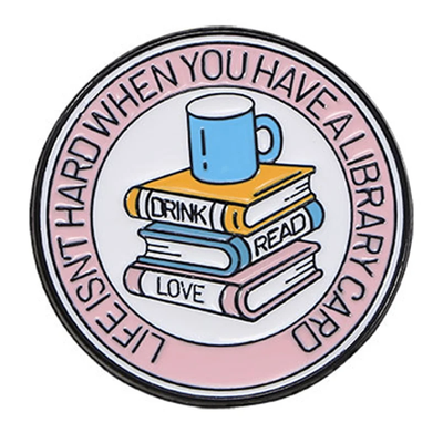 The "Life Isn't Hard When You Have A Library Card" Enamel Pin features a stack of books in the centre (plus a cup of sweet, sweet coffee!), within a ring of text proclaiming your love for libraries.