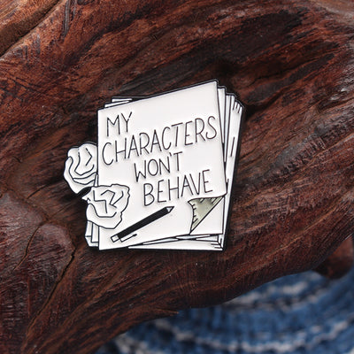 The "My Characters Won't Behave" Enamel Pin is an average-sized brooch featuring a stylised stack of pen and papers, with pile of crumpled sheets to pay tribute to just how naughty your characters are today. Only one way to get them back in order... keep going!