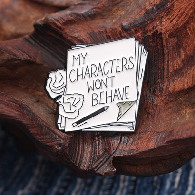 The "My Characters Won't Behave" Enamel Pin is an average-sized brooch featuring a stylised stack of pen and papers, with pile of crumpled sheets to pay tribute to just how naughty your characters are today. Only one way to get them back in order... keep going!