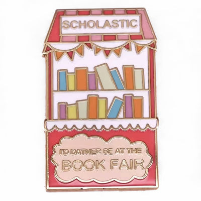 The "Scholastic Book Fair" Enamel Pin features a stylised bookshelf in lovely pastel shades of pink, coral, and gold, commemorating everyone's favourite childhood memory: The Scholastic Book Fair! Oh, the joy! So many books!