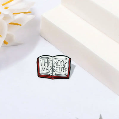 The "The Book Was Better" Enamel Pin features a stylised red book with large text loudly proclaiming just how much better the book was, as every book-lover knows.
