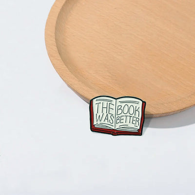 The "The Book Was Better" Enamel Pin features a stylised red book with large text loudly proclaiming just how much better the book was, as every book-lover knows.