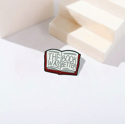 The "The Book Was Better" Enamel Pin features a stylised red book with large text loudly proclaiming just how much better the book was, as every book-lover knows.