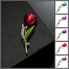 The Gretchen Enamel Tulip Brooch - A tall, slender enamel flower brooch with a colourful flower head and delicate round crystals along one of the leads.