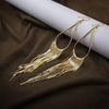 Jahzara Tassel Earrings - Long stylish statement dangles, featuring a hollow teardrop shape with tassels strung off it.