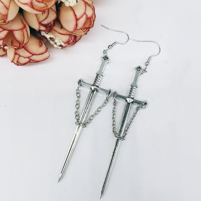 Joan Chained Crusader Sword Earrings - A long stylised silver sword charm attached to a standard french hook.