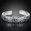 Jocasta Cut-Out Silver Cuff Bangle - An elegant yet chunky silver cuff with a floral/vine-like cut-out pattern, made from bright silver.