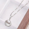 Kaimana Seashell Necklace - An elegant silver-coloured necklace featuring a seashell with a pearl at the end.