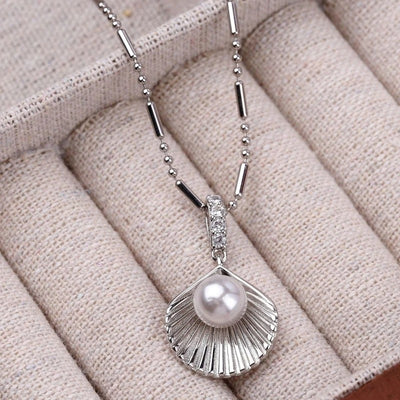 Kaimana Seashell Necklace - An elegant silver-coloured necklace featuring a seashell with a pearl at the end.