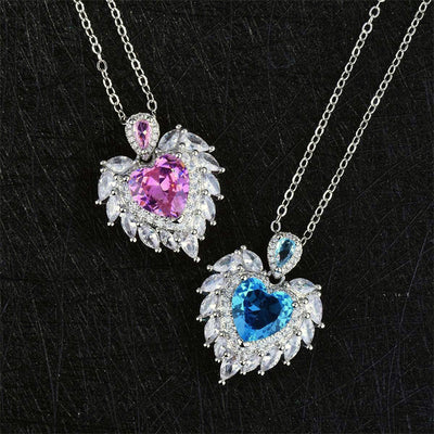 Katherine Luxury Crystal Pendant - A beautiful crystal pendant featuring a pink or blue topaz heart in the centre, surrounded by white topaz stones arranged to look like angel wings.