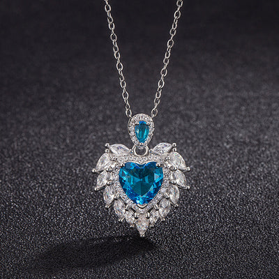 Katherine Luxury Crystal Pendant - A beautiful crystal pendant featuring a pink or blue topaz heart in the centre, surrounded by white topaz stones arranged to look like angel wings.