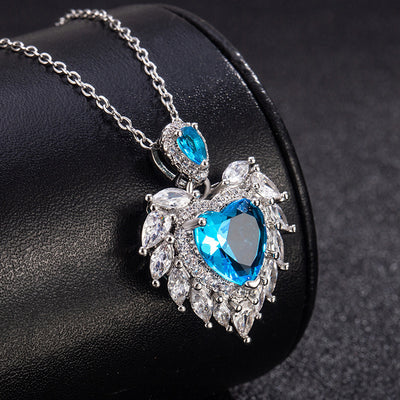 Katherine Luxury Crystal Pendant - A beautiful crystal pendant featuring a pink or blue topaz heart in the centre, surrounded by white topaz stones arranged to look like angel wings.