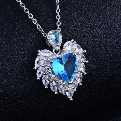 Katherine Luxury Crystal Pendant - A beautiful crystal pendant featuring a pink or blue topaz heart in the centre, surrounded by white topaz stones arranged to look like angel wings.