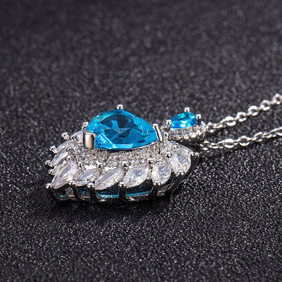 Katherine Luxury Crystal Pendant - A beautiful crystal pendant featuring a pink or blue topaz heart in the centre, surrounded by white topaz stones arranged to look like angel wings.