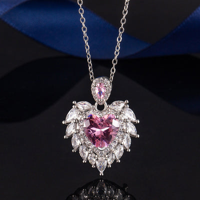 Katherine Luxury Crystal Pendant - A beautiful crystal pendant featuring a pink or blue topaz heart in the centre, surrounded by white topaz stones arranged to look like angel wings.