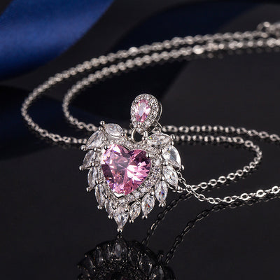 Katherine Luxury Crystal Pendant - A beautiful crystal pendant featuring a pink or blue topaz heart in the centre, surrounded by white topaz stones arranged to look like angel wings.