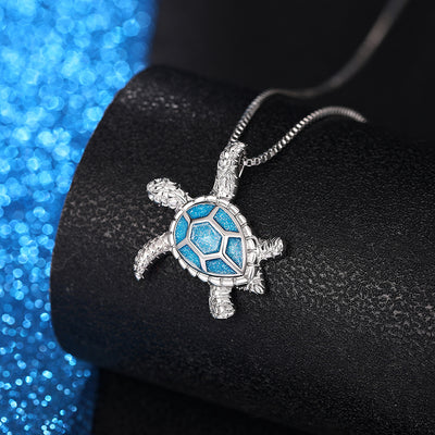 Kealoha Iridescent Resin Turtle Necklace - A delicate silver coloured box chain with a small silver coloured pendant of a stylised turtle, with sparkly blue resin panels on its shell.