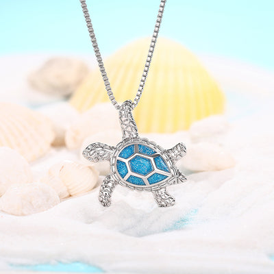 Kealoha Iridescent Resin Turtle Necklace - A delicate silver coloured box chain with a small silver coloured pendant of a stylised turtle, with sparkly blue resin panels on its shell.
