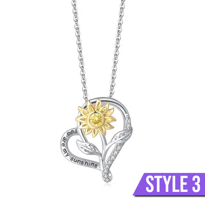 The Kelly Sunflower Heart Necklace - An elegant floral-themed necklace featuring a platinum plated heart with a beautiful yellow gold sunflower, and sparkling crystals.