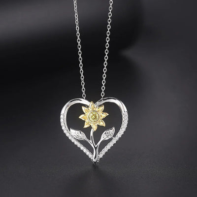 The Kelly Sunflower Heart Necklace - An elegant floral-themed necklace featuring a platinum plated heart with a beautiful yellow gold sunflower, and sparkling crystals.