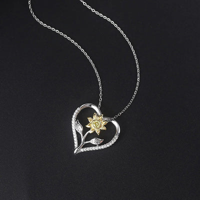 The Kelly Sunflower Heart Necklace - An elegant floral-themed necklace featuring a platinum plated heart with a beautiful yellow gold sunflower, and sparkling crystals.