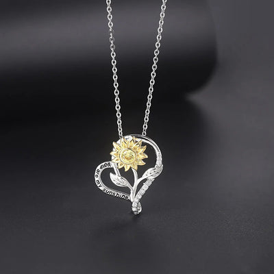 The Kelly Sunflower Heart Necklace - An elegant floral-themed necklace featuring a platinum plated heart with a beautiful yellow gold sunflower, and sparkling crystals.