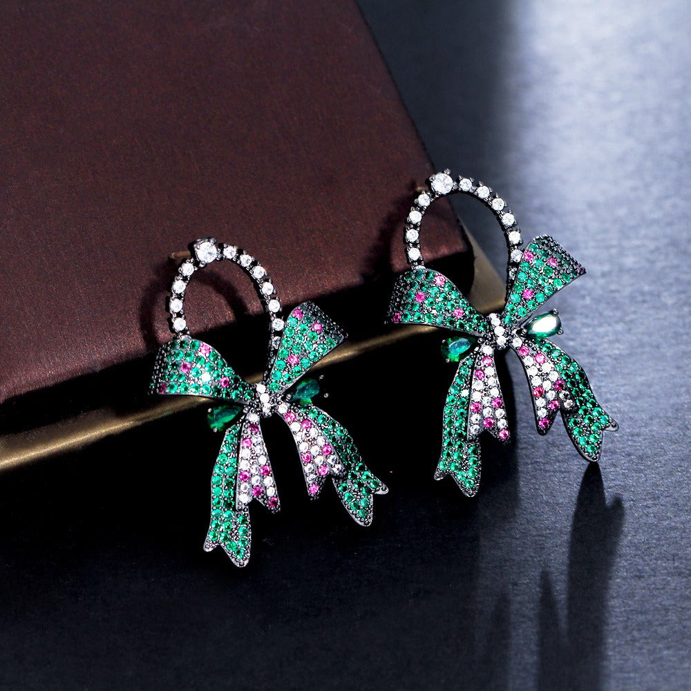 Marzanna Bowknot Statement Earrings - Large crystal-encrusted stud earrings shaped like an elegant bow, with green, pink, and white stones.