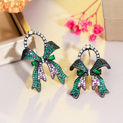 Marzanna Bowknot Statement Earrings - Large crystal-encrusted stud earrings shaped like an elegant bow, with green, pink, and white stones.