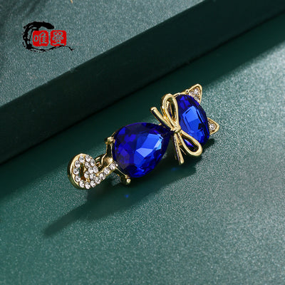 Mimmy Crystal Cat Brooch - A cute, stylised cat brooch featuring large coloured crystals for the head and body, and small round white quartz set into the ears and tail.