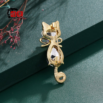 Mimmy Crystal Cat Brooch - A cute, stylised cat brooch featuring large coloured crystals for the head and body, and small round white quartz set into the ears and tail.