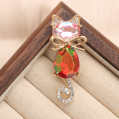 Mimmy Crystal Cat Brooch - A cute, stylised cat brooch featuring large coloured crystals for the head and body, and small round white quartz set into the ears and tail.