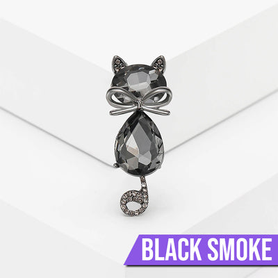 Mimmy Crystal Cat Brooch - A cute, stylised cat brooch featuring large coloured crystals for the head and body, and small round white quartz set into the ears and tail.