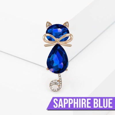 Mimmy Crystal Cat Brooch - A cute, stylised cat brooch featuring large coloured crystals for the head and body, and small round white quartz set into the ears and tail.