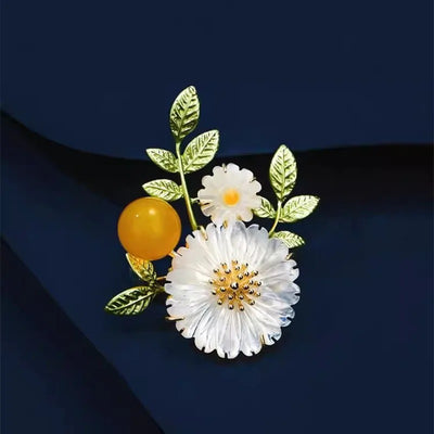 Nadine Daisy Enamel & Shell Brooch - A medium-sized, elegant floral brooch featuring two small stylised daisies, leaves, and a yellow ball.