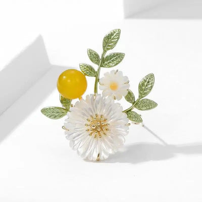 Nadine Daisy Enamel & Shell Brooch - A medium-sized, elegant floral brooch featuring two small stylised daisies, leaves, and a yellow ball.