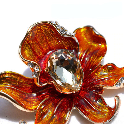 The Odessa Enamel Orchid Brooch - A lovely flower-themed brooch featuring six wavy petals around a large teardrop-shaped central stone.