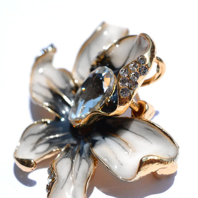 The Odessa Enamel Orchid Brooch - A lovely flower-themed brooch featuring six wavy petals around a large teardrop-shaped central stone.