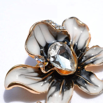 The Odessa Enamel Orchid Brooch - A lovely flower-themed brooch featuring six wavy petals around a large teardrop-shaped central stone.