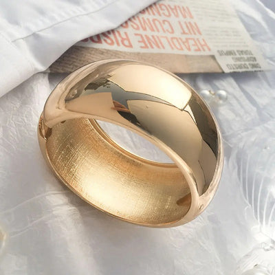 Ovalyn Hinged Cuff Bangle - A simple round gold bangle with a mirrored finish, available in champagne or white gold.