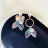 Pearla Iridescent Acrylic Earrings - Lovely lopsided iridescent earrings with a seaside theme, featuring seashells, fish tails, crystals, and pearls.