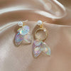 Pearla Iridescent Acrylic Earrings - Lovely lopsided iridescent earrings with a seaside theme, featuring seashells, fish tails, crystals, and pearls.