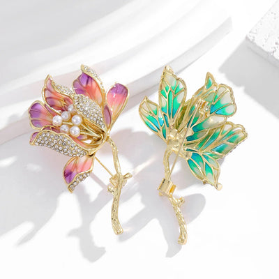 The Helena Hibiscus Sculpted Resin Brooch is a lovely, long, elegant piece that features seven ruffled petals clustered around a sprig of pearl stamen, with colourful resin to really make it pop and a dusting of crystal along the underside of the petals.