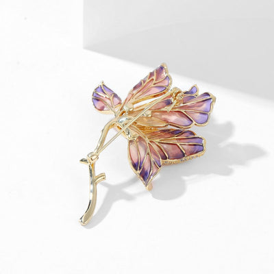 The Helena Hibiscus Sculpted Resin Brooch is a lovely, long, elegant piece that features seven ruffled petals clustered around a sprig of pearl stamen, with colourful resin to really make it pop and a dusting of crystal along the underside of the petals.