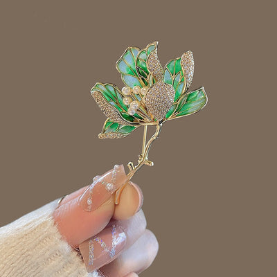 The Helena Hibiscus Sculpted Resin Brooch is a lovely, long, elegant piece that features seven ruffled petals clustered around a sprig of pearl stamen, with colourful resin to really make it pop and a dusting of crystal along the underside of the petals.