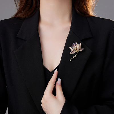 The Helena Hibiscus Sculpted Resin Brooch is a lovely, long, elegant piece that features seven ruffled petals clustered around a sprig of pearl stamen, with colourful resin to really make it pop and a dusting of crystal along the underside of the petals.