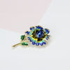 Piper Enamel Primrose Brooch - A detailed floral brooch featuring a large central stone with ruffled enamel petals surrounding it, painted with vibrant enamel paint.