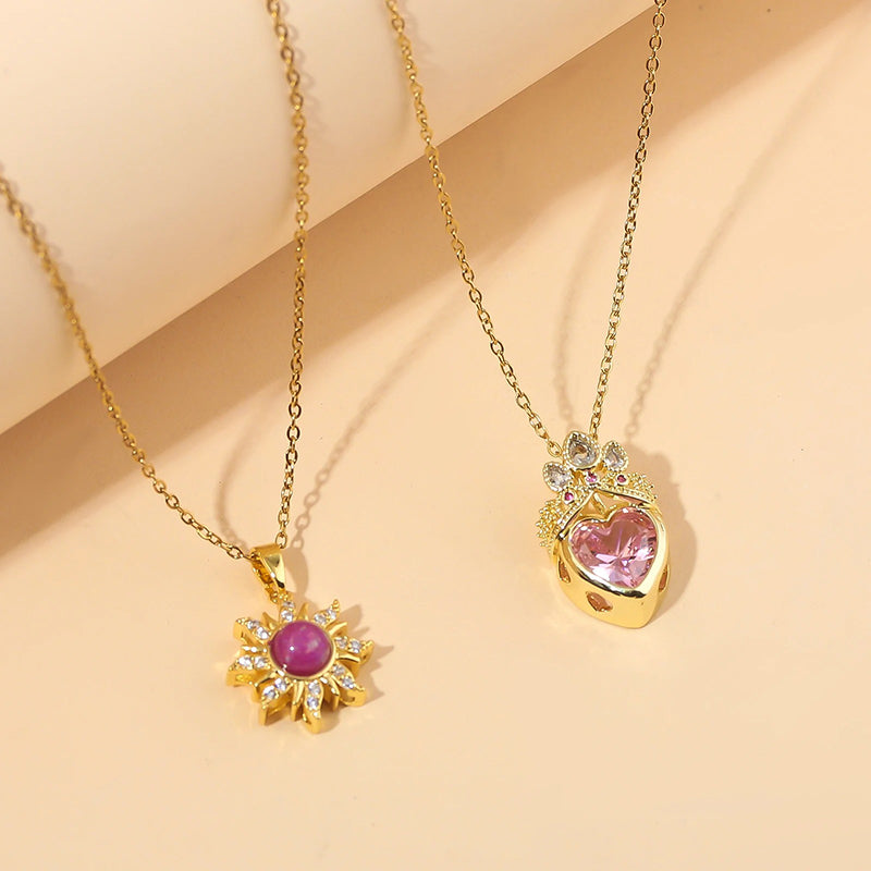 Pretty Pretty Princess Royal Heart & Sun Necklace Set - A delicate jewellery set featuring a matched pair of necklaces with pink crystals and gold-toned metal.