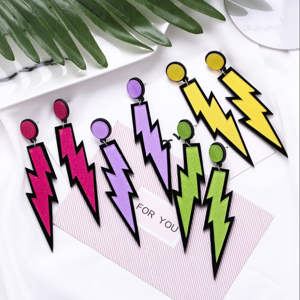 Retro Revival Bolt Outta The Lobe Post Earrings - Large, colourful lightning bolt earrings made from vivid acrylic plastic, with a black background that looks like the outline of a comic book character.