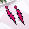 Retro Revival Bolt Outta The Lobe Post Earrings - Large, colourful lightning bolt earrings made from vivid acrylic plastic, with a black background that looks like the outline of a comic book character.