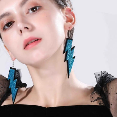 Retro Revival Lightning Strikes Twice Hook Earrings - Large, colourful lightning bolt earrings made from vivid acrylic plastic, with a black background that looks like the outline of a comic book character.